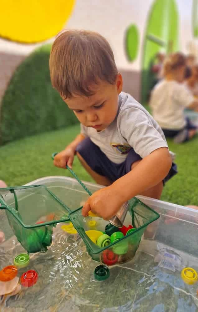 Campamento de verano niños 1 año jugando con agua